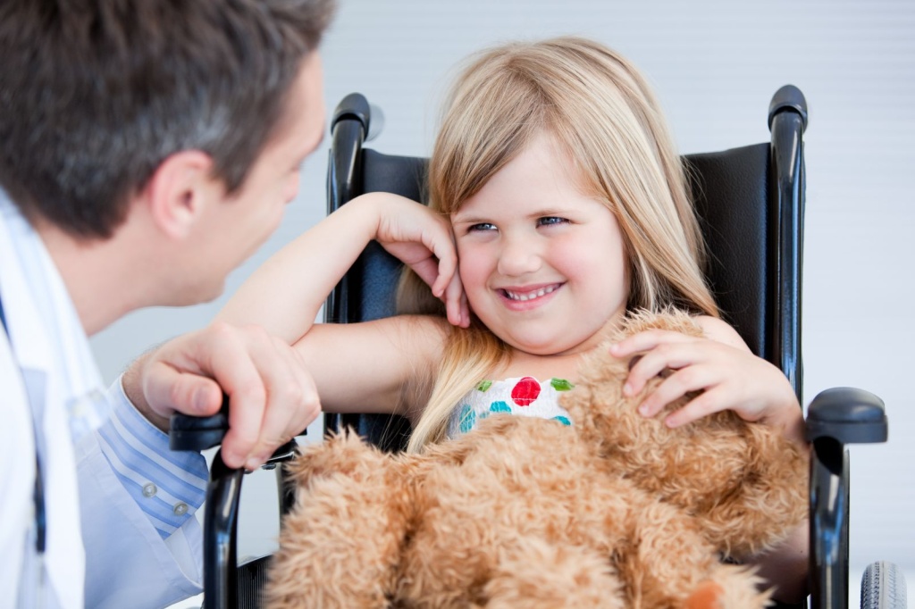 Девочка в инвалидной коляске с врачом